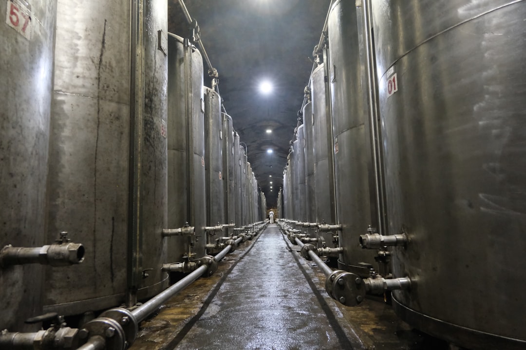 Industrial stainless steel tanks in a long hallway.