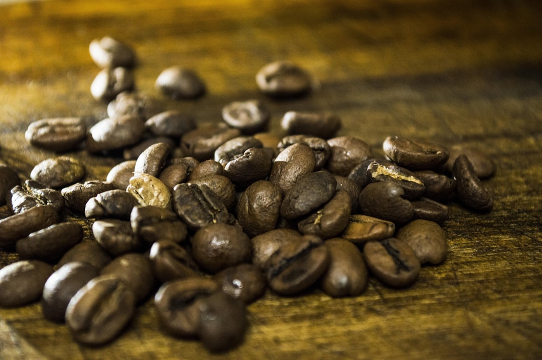 a pile of coffee beans sitting on top of a wooden table