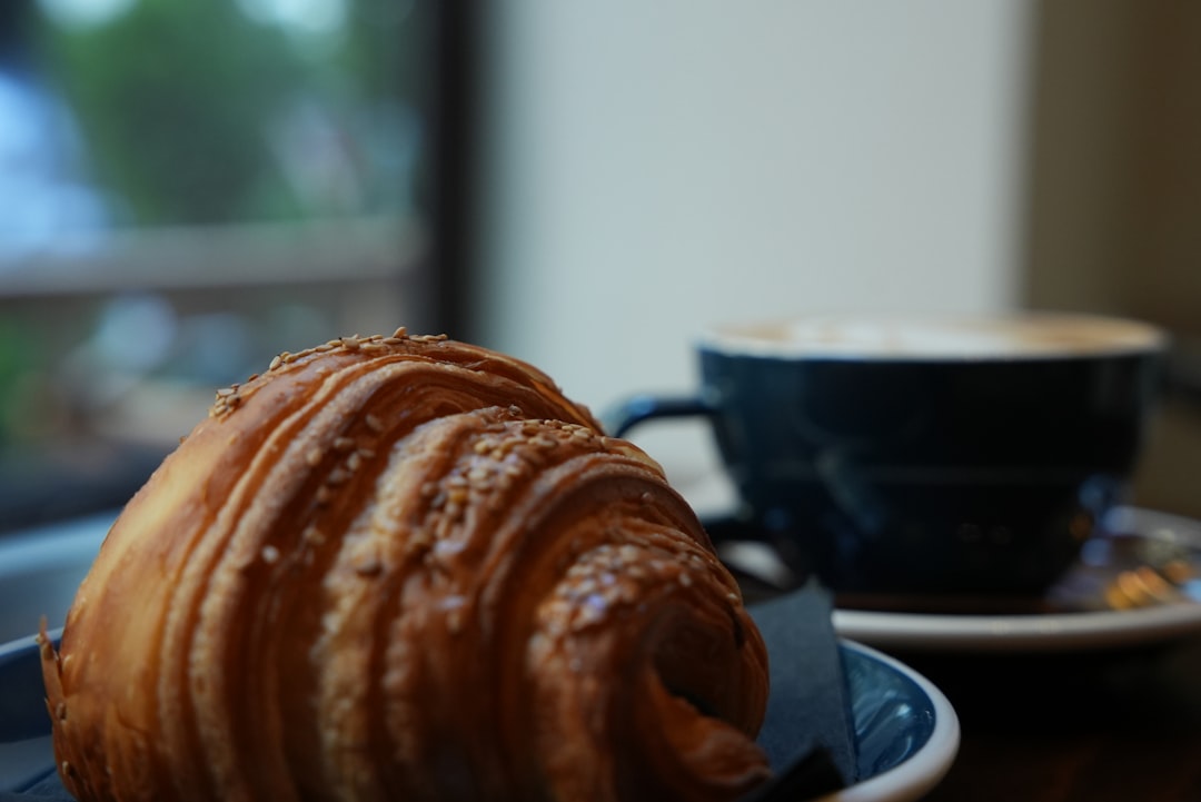 A croissant and a cup of coffee on a table