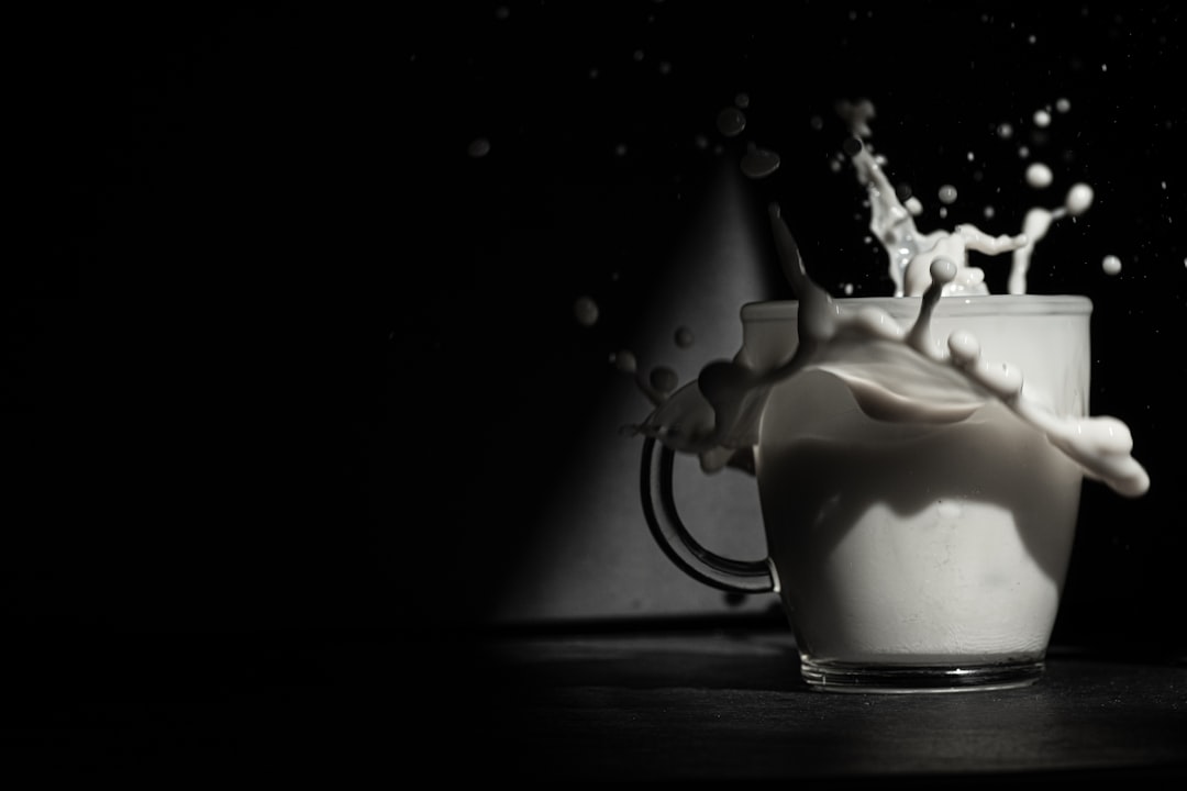 a glass of milk with a splash of milk on top of it