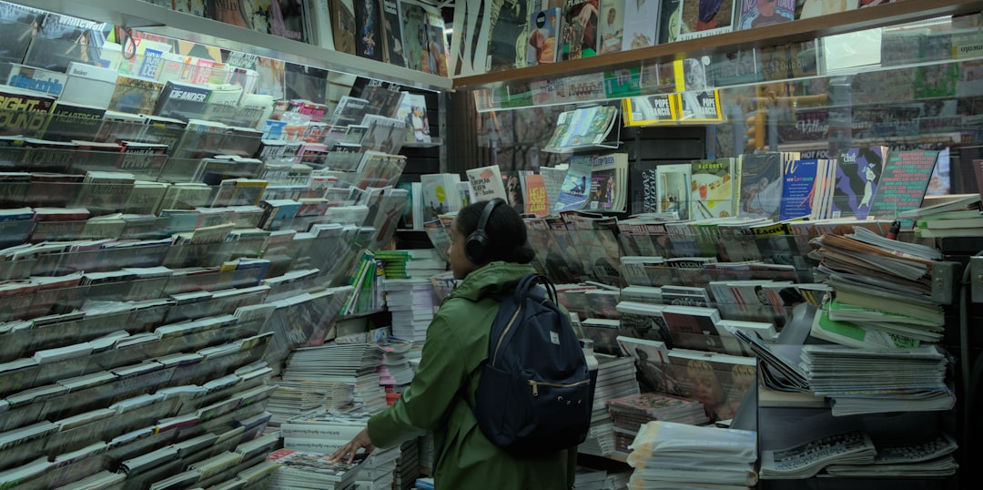 Person browsing shelves filled with books and magazines.