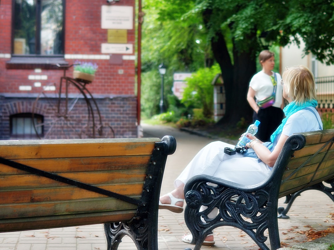 Woman relaxing on a park bench with a water bottle.