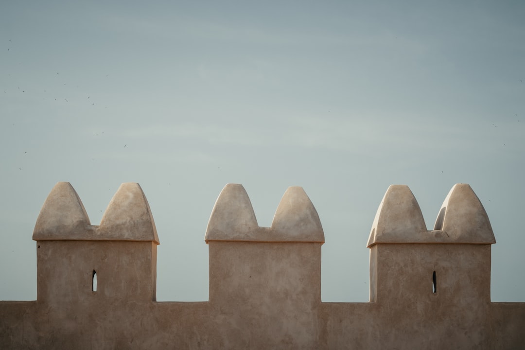 Battlements of an ancient stone wall against sky