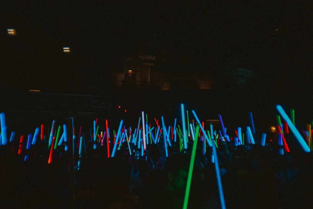Many glowing light sticks fill the dark space.
