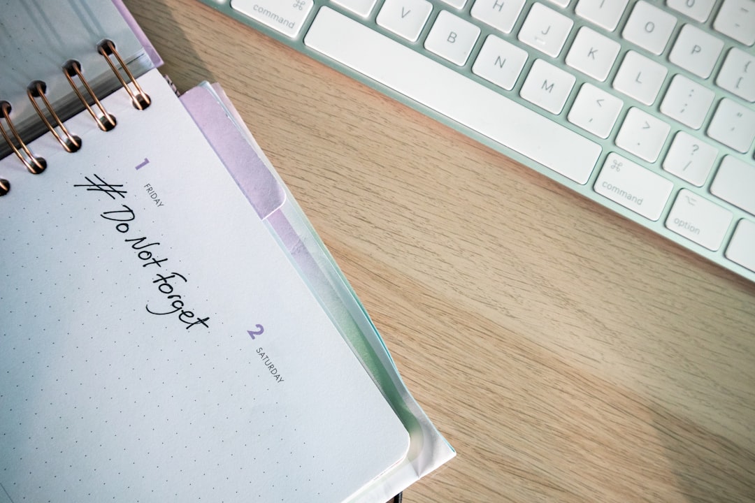 a notepad sitting on top of a wooden desk next to a keyboard